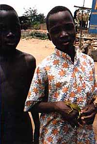 Michel stands next to a friend holding a chameleon.