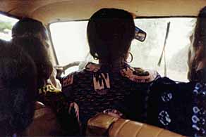 3 people sit in the taxi's front.