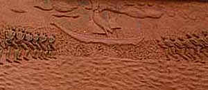 Two lines of slaves converge towards the awaiting slave ship.